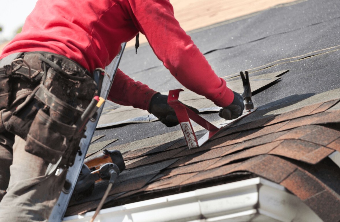 Professional roofer removing damaged shingles during roof repair in Berkeley, CA